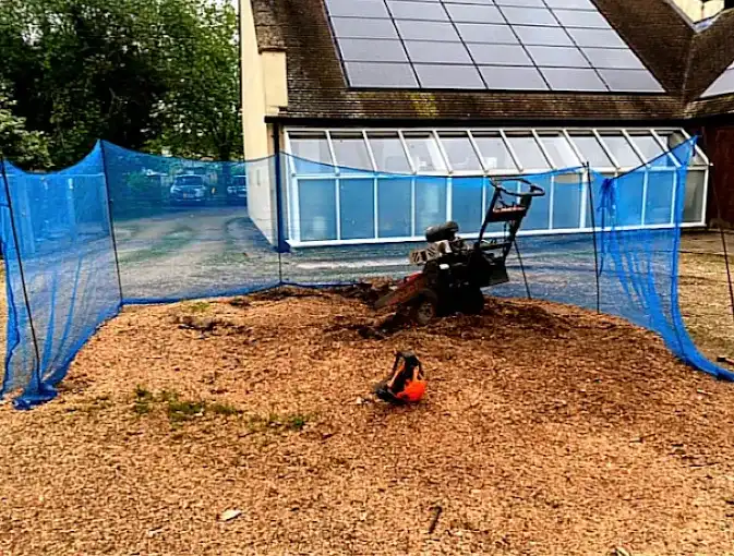 A stump grinding machine with blue netting